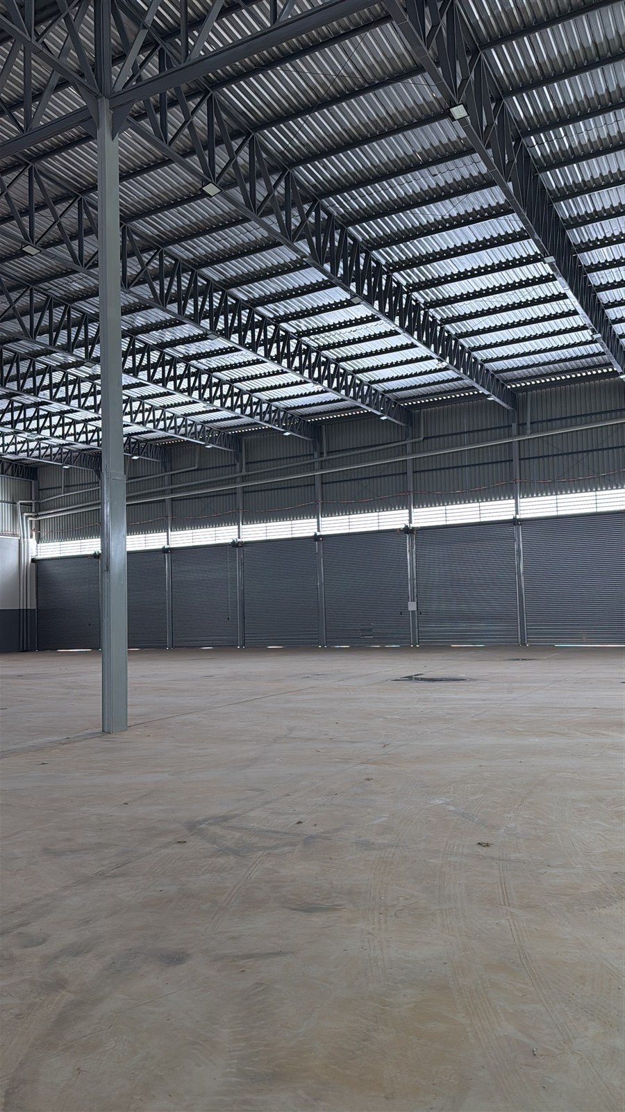 Interior de galpão com estrutura metálica e piso de concreto